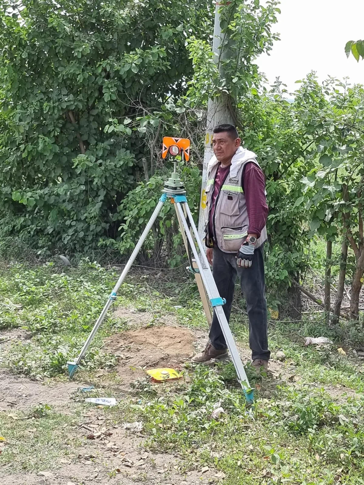 Profesional de DYSCONCSA junto al equipo de levantamiento topográfico en campo
