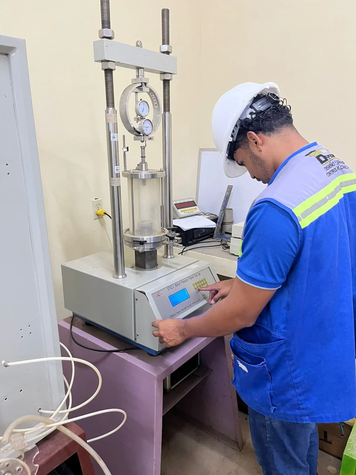 Técnico de DYSCONCSA realizando un ensayo triaxial de suelos en el laboratorio